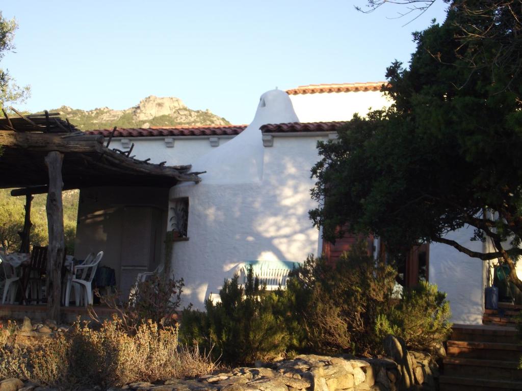 ein weißes Haus mit einem Tisch und Stühlen in der Unterkunft Casa Marcella Cugnana-Portisco in Cugnana