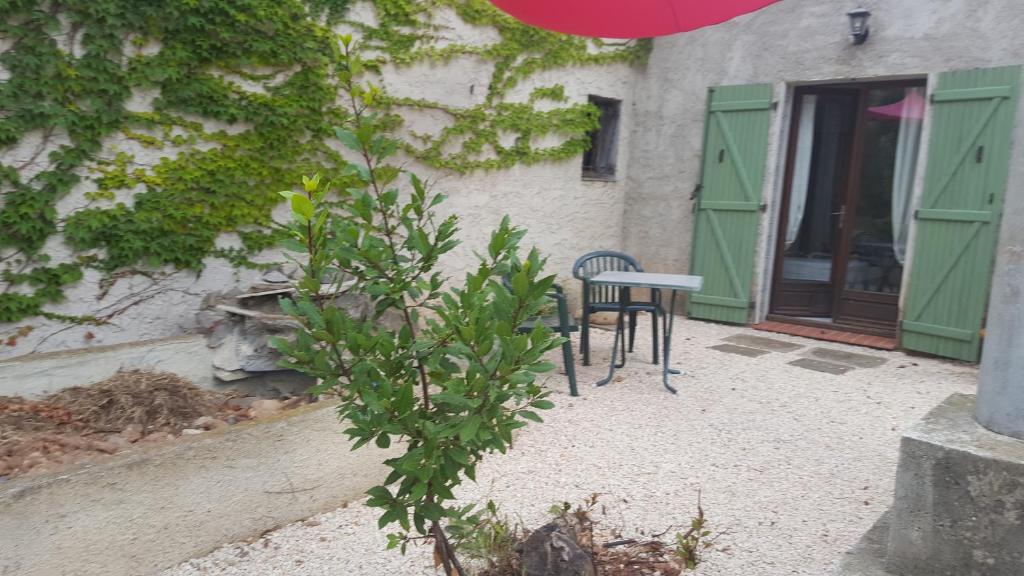 une table et une chaise devant le bâtiment dans l'établissement Aux Oliviers, à Homps