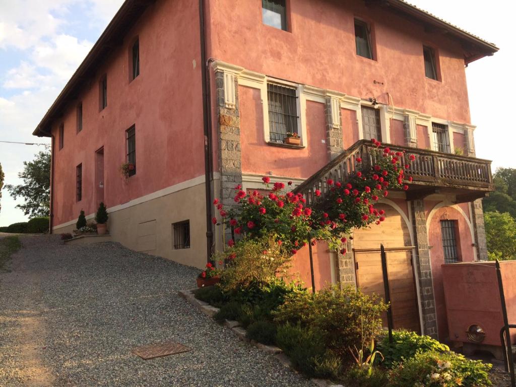 a building with a balcony with red flowers on it at La Carosera in Castellengo