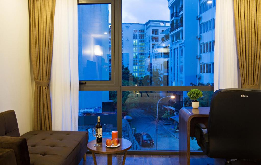 een woonkamer met een bank en een groot raam bij Inearth Hotel in Hanoi