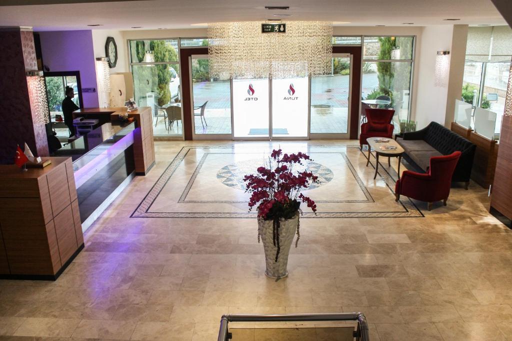 een lobby met een vaas met bloemen op de vloer bij Tuna Hotel in Mugla