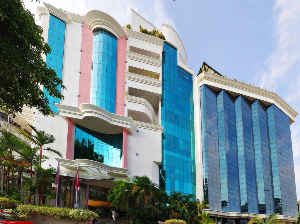 un bâtiment avec des fenêtres bleues sur une rue de la ville dans l'établissement Residency Tower, à Trivandrum