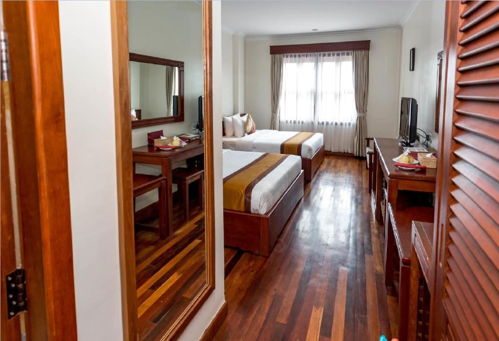 Postel nebo postele na pokoji v ubytování Saem Siemreap Hotel
