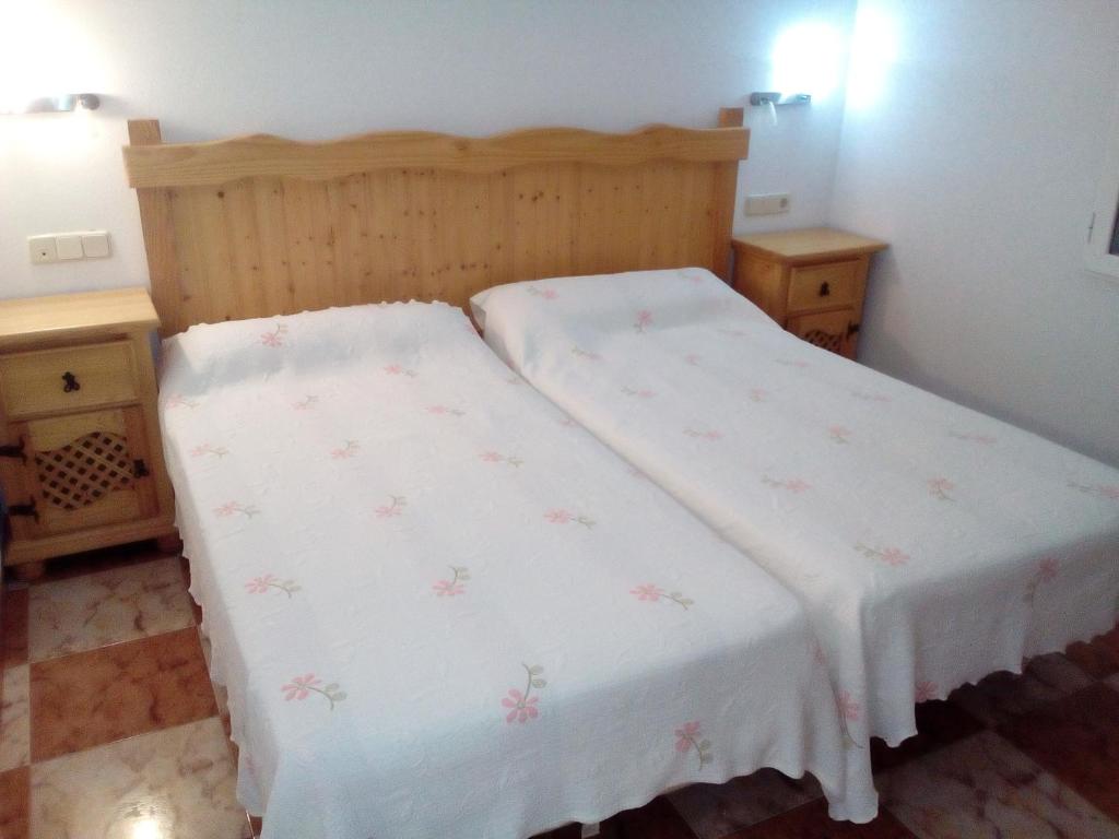 een kleine slaapkamer met een bed met een witte deken bij El Molino in Ruidera