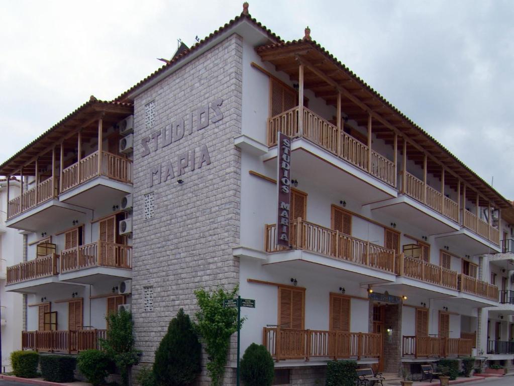 a large white building with wooden balconies at Studios Maria in Paralion astros