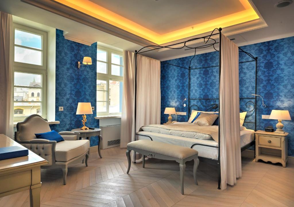 - une chambre avec des murs bleus, un lit et une chaise dans l'établissement Relais Le Chevalier, à Riga