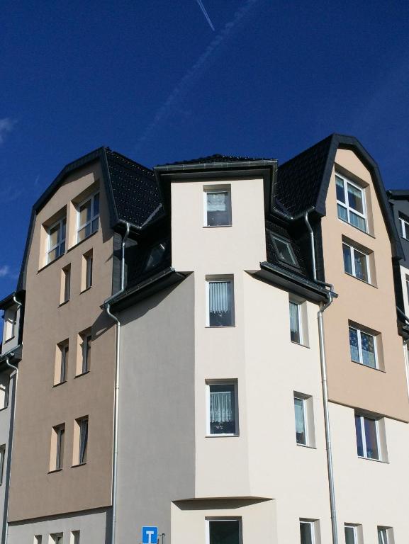 ein hohes weißes Gebäude mit einem schwarzen Dach in der Unterkunft Formella in Eisenach