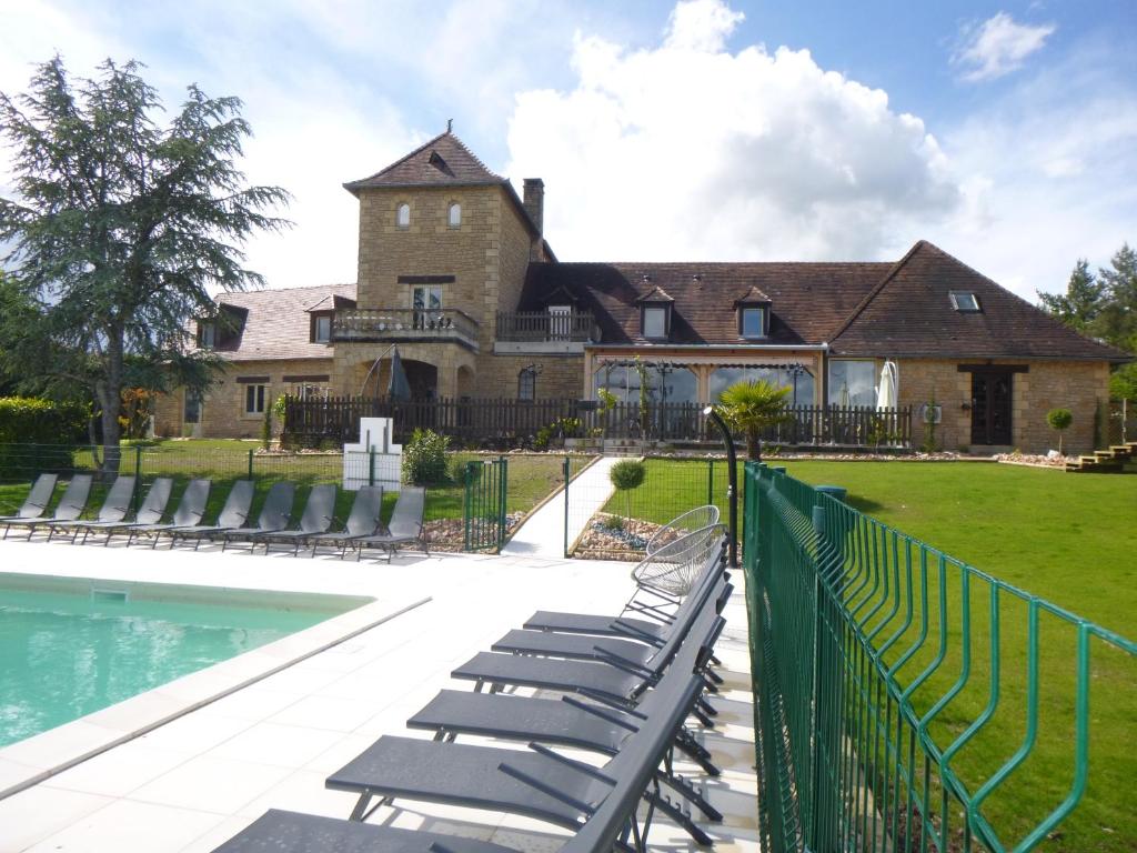 a house with a swimming pool and chairs at Logis hotel-restaurant les collines 59 route des crêtes in Cublac