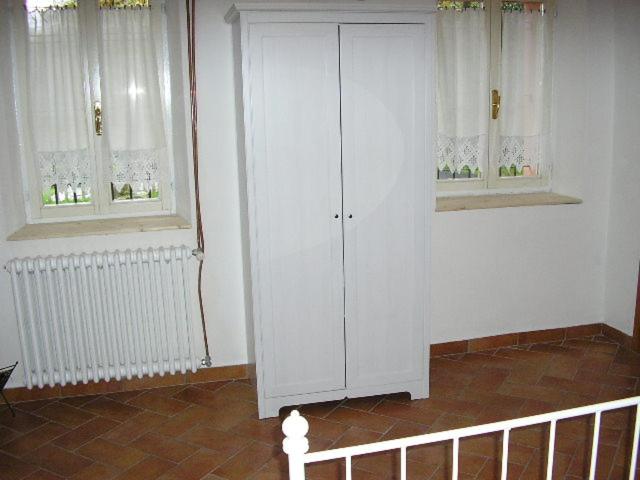 a white cabinet in a room with two windows at B&B IL BOSCHETTO in Calestano