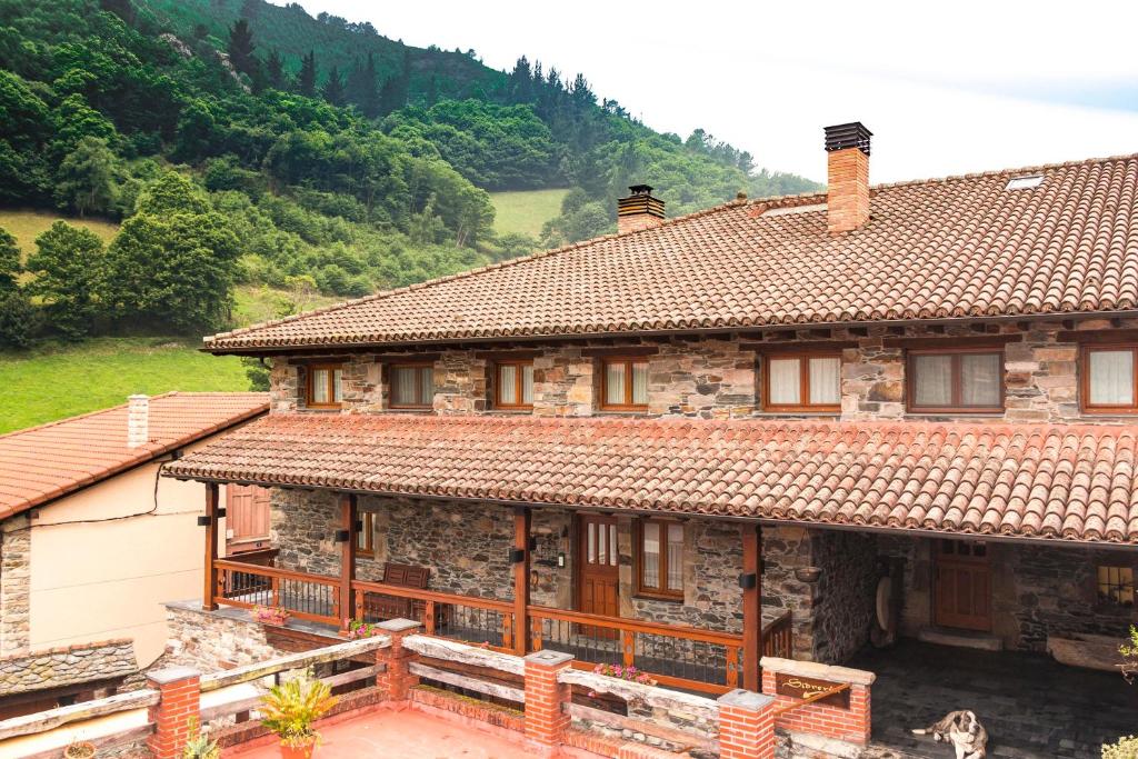 an old house with a view of a mountain at Casa Gayón in Pola de Allande