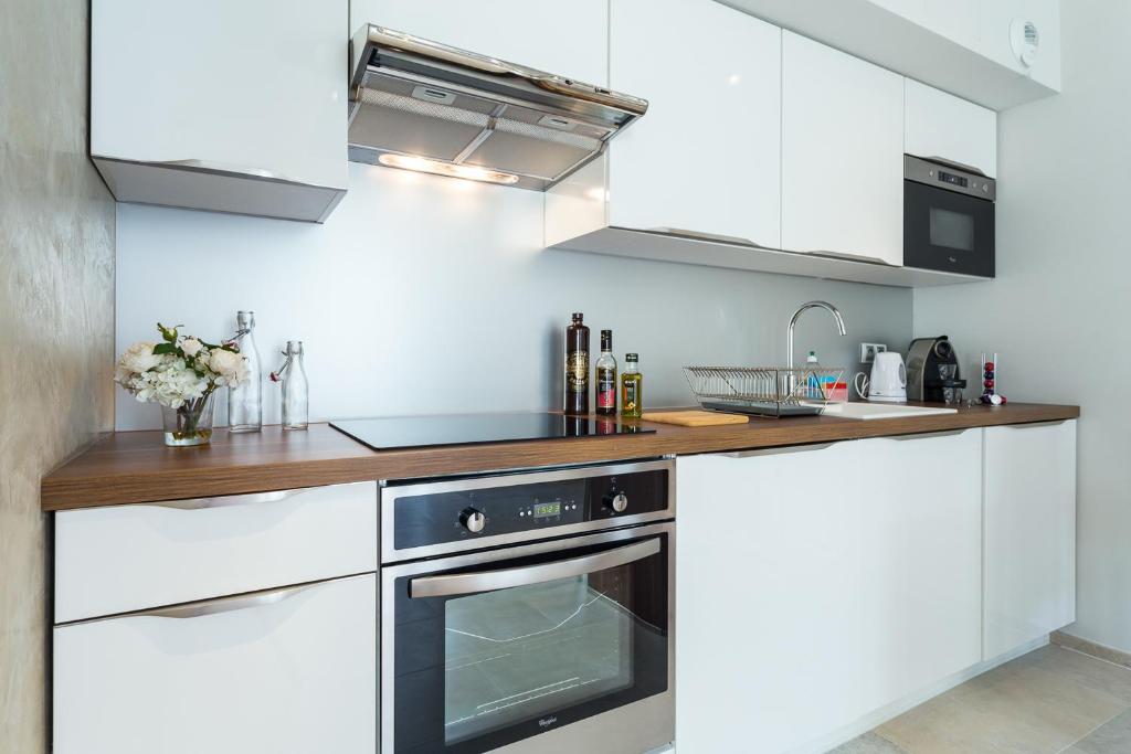 a kitchen with white cabinets and a black oven at Villa Velvet in Villeneuve-Loubet