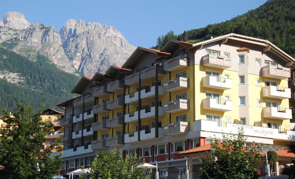 a building with a mountain in the background at Alpenresort Belvedere Wellness & Beauty in Molveno