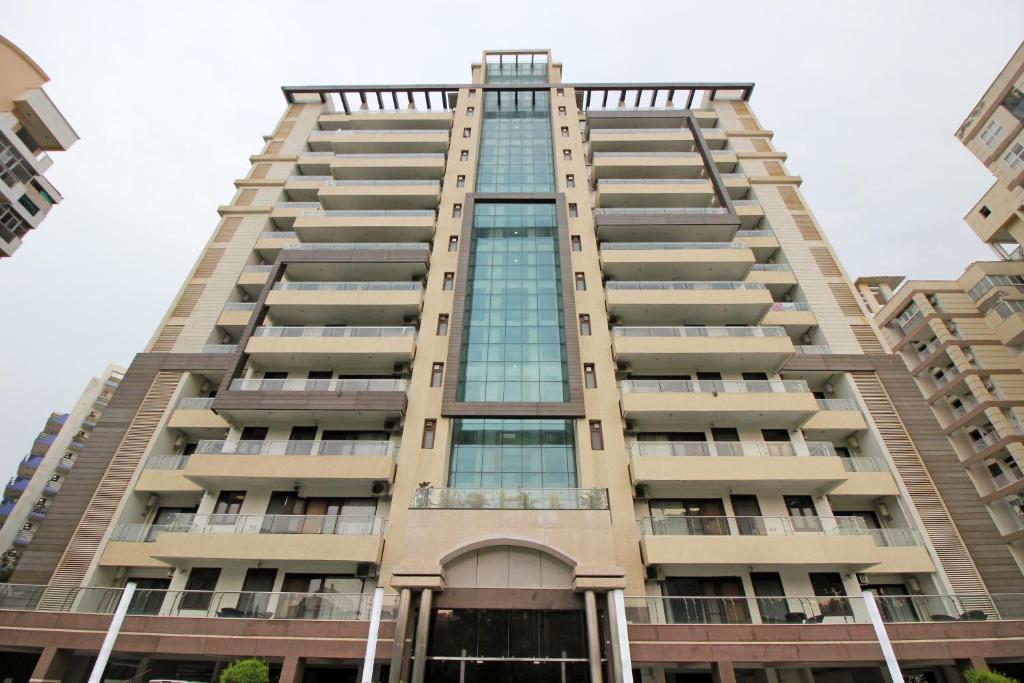 a tall apartment building with windows at Gazebo Inn & Suites Medanta in Gurgaon