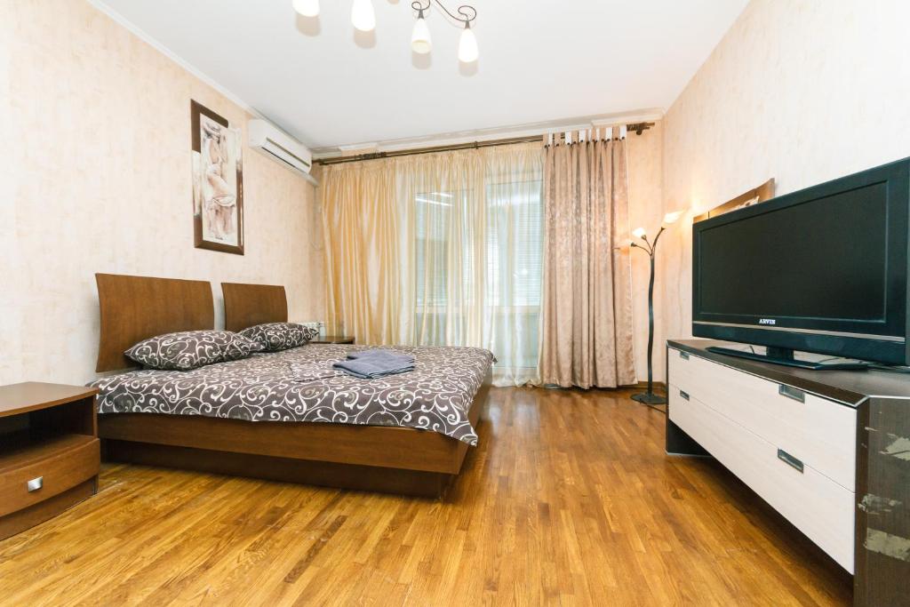 a bedroom with a bed and a flat screen tv at Two-storey apartment near IEC in Kyiv