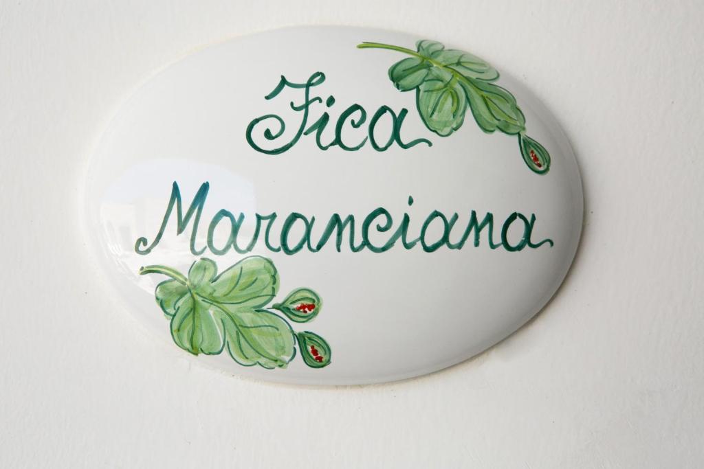 a white plate with a sign for a sign manufacturer at Antica Masseria Ficazzana - Tenuta in Marina di Pescoluse