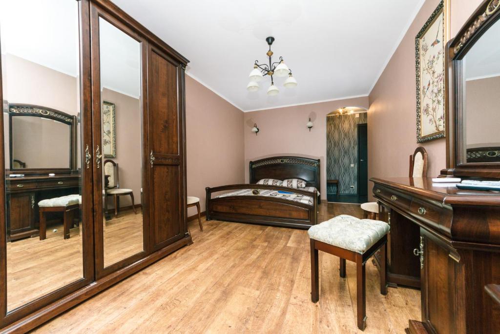 a bedroom with a bed and a desk and a mirror at Apartment on Cheliabinska 19 in Kyiv