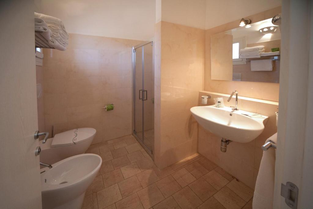 a bathroom with a toilet and a sink and a shower at Antica Masseria Ficazzana - Tenuta in Marina di Pescoluse