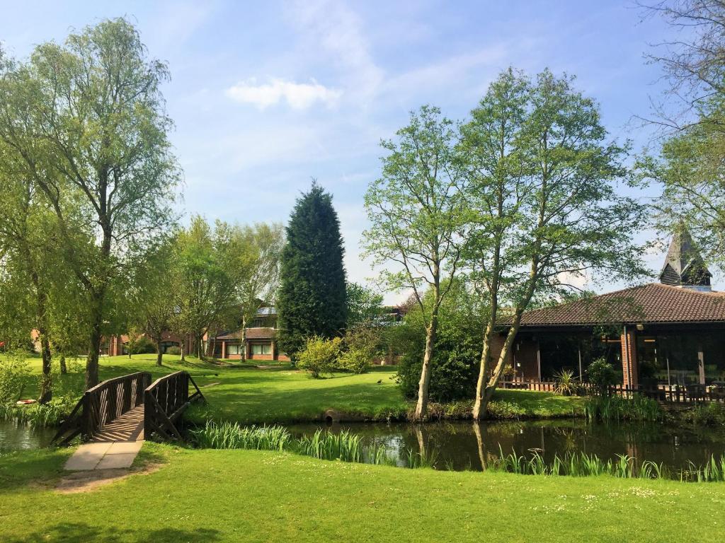 un ponte sopra un fiume accanto a una casa di Lea Marston Hotel a Lea Marston