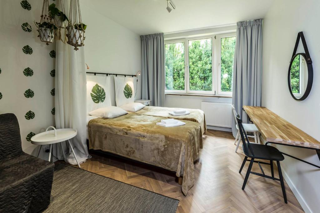a bedroom with a bed and a table and a desk at Irysowy Premium Hostel in Warsaw