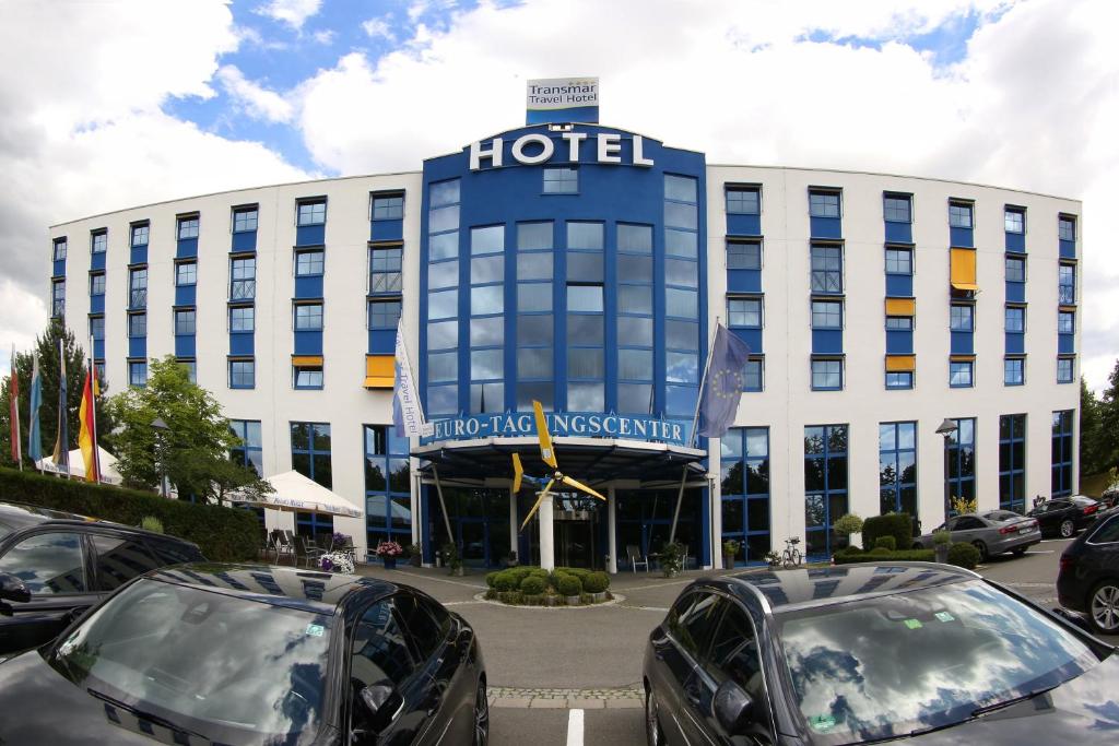 a hotel with cars parked in front of it at Transmar Travel Hotel in Bindlach