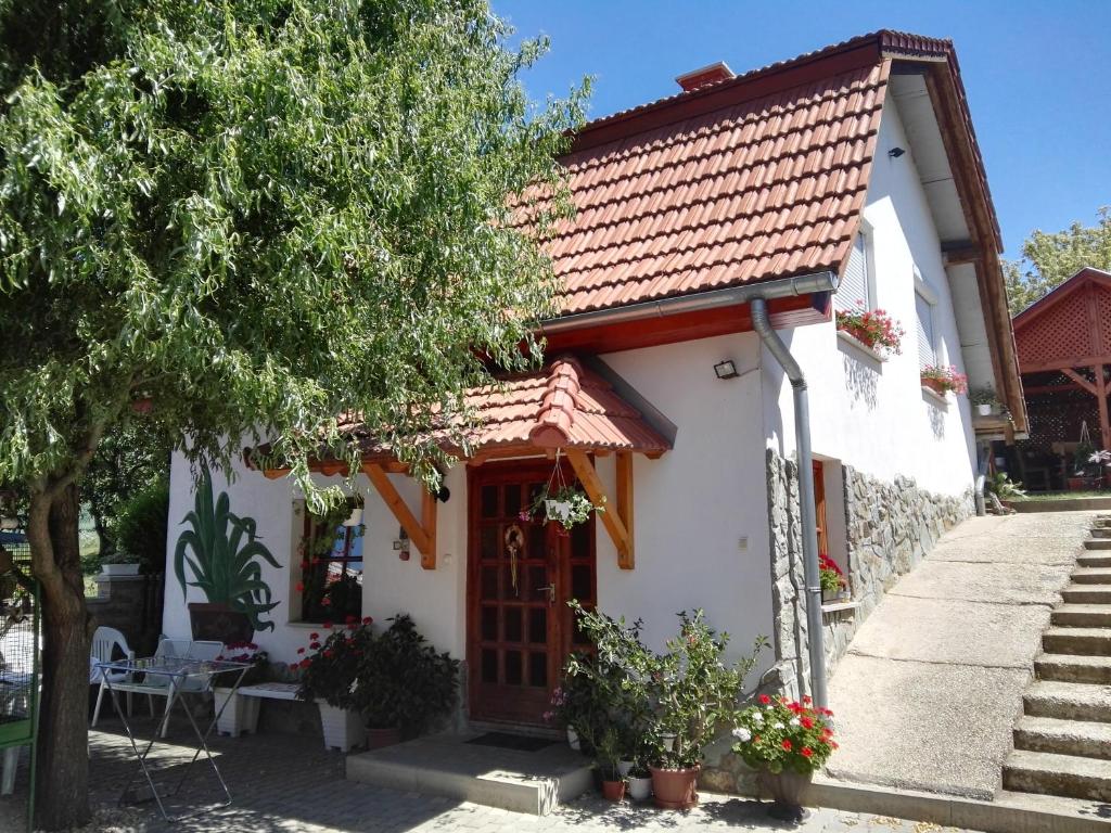 una pequeña casa blanca con techo rojo en Agávé Apartman, en Sárvár
