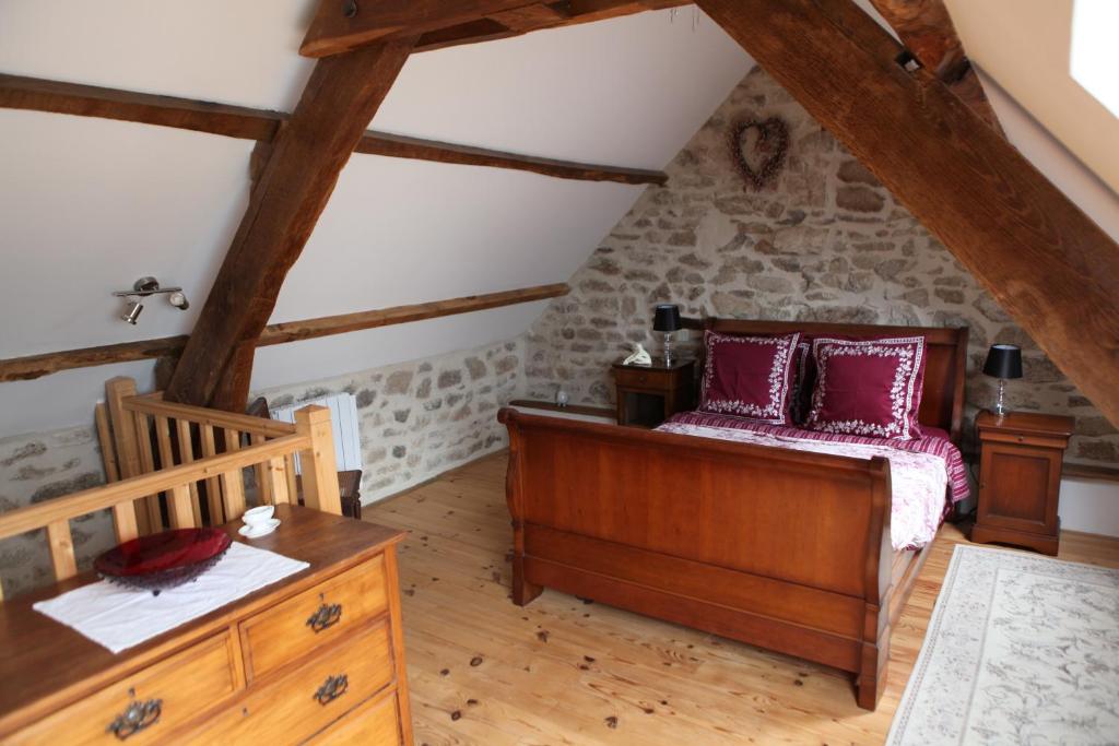 ein Schlafzimmer mit einem Bett und einem Tisch im Dachgeschoss in der Unterkunft Castle Terrace in Faux-la-Montagne