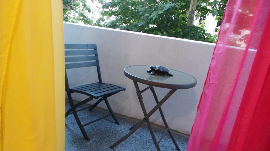 a small table and a chair on a balcony at Catalans in Marseille