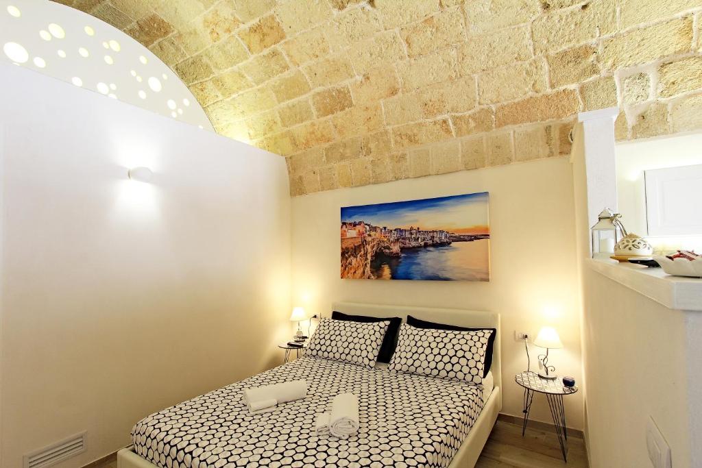 sypialnia z łóżkiem i ceglaną ścianą w obiekcie Il Viandante w mieście Polignano a Mare