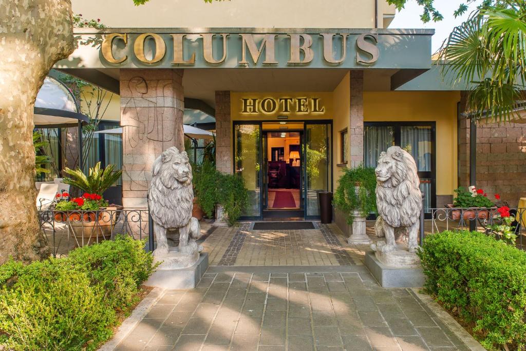 a hotel with two lion statues in front of it at Hotel Columbus sul Lago in Bolsena