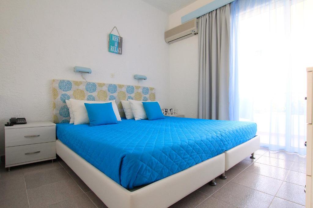 
a blue and white bed in a bedroom at Christiana Hotel Apartments in Gennadi
