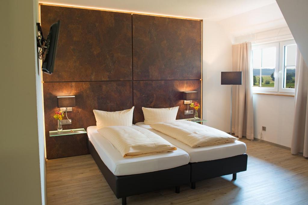 バート・ヴルツァッハにあるTruschwende 4のベッドルーム1室(大型ベッド1台、木製ヘッドボード付)