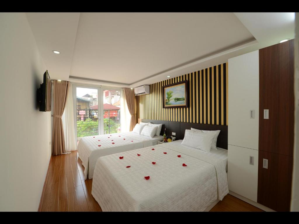a bedroom with two beds with red roses on them at Hanoi Golden Hostel in Hanoi