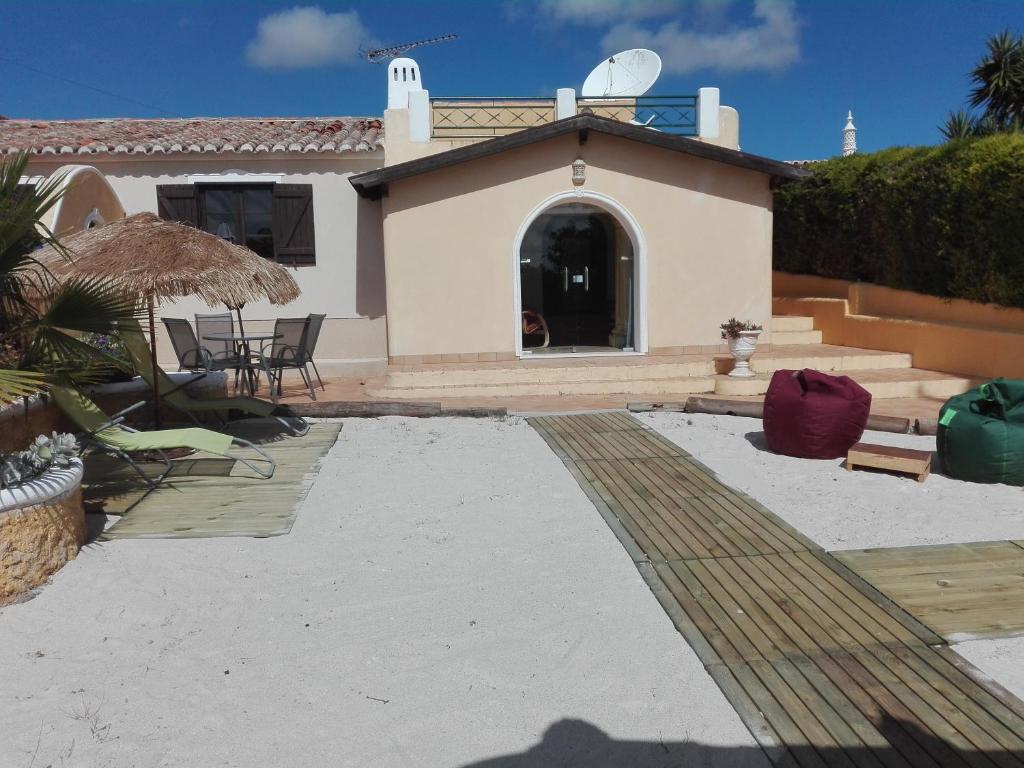 une maison avec une terrasse, une table et des chaises dans l'établissement Nature Beach Resort Quinta Al-Gharb, à Vila do Bispo
