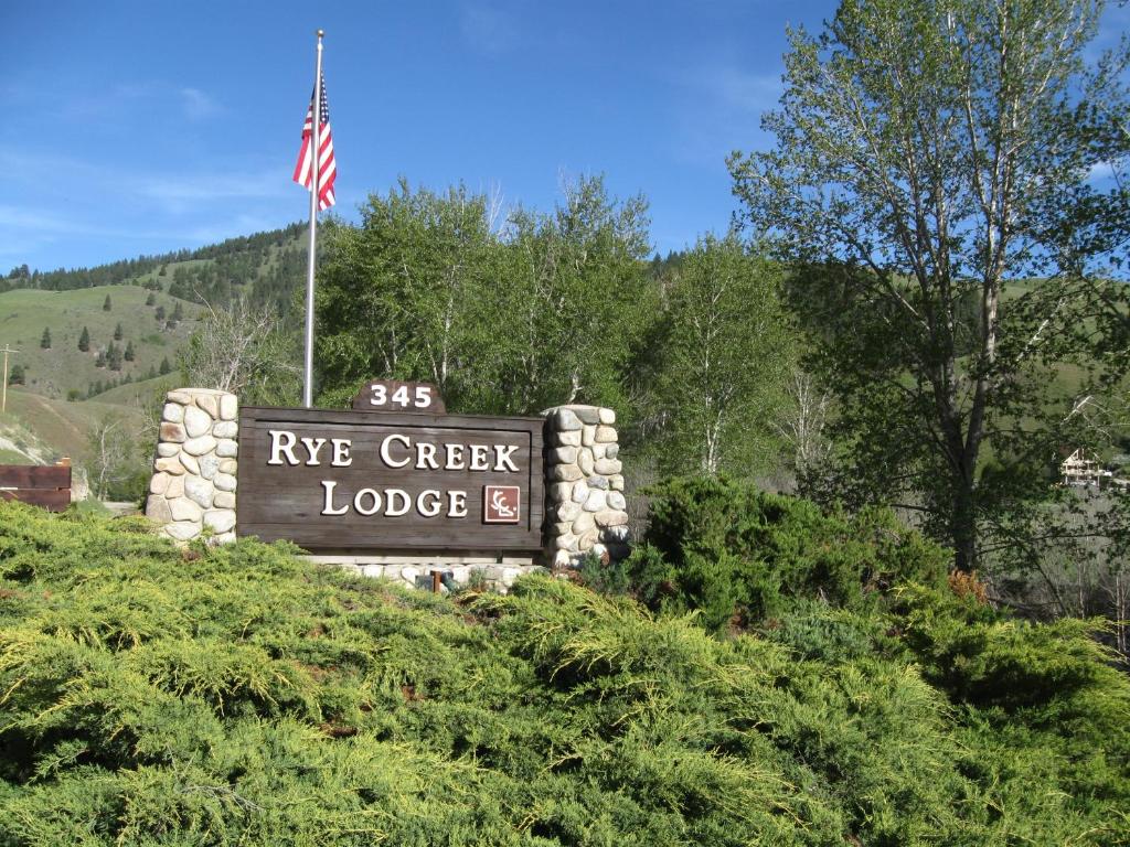 Una señal para Ayr Creek Lodge con bandera americana en Rye Creek Lodge en Darby