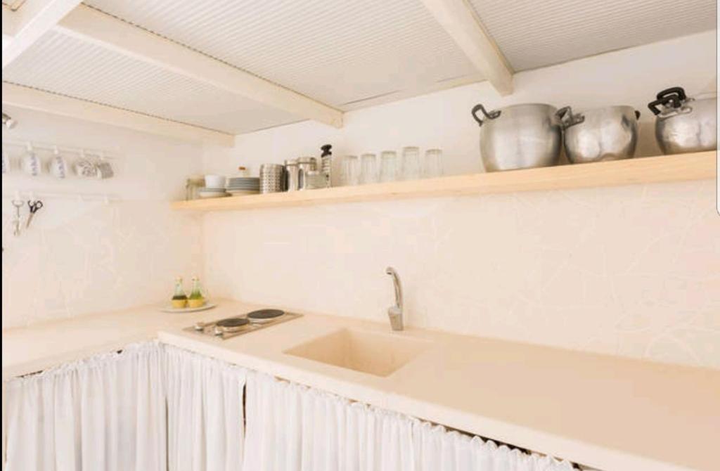 奧斯圖尼的住宿－Loft Marilyn，厨房配有水槽和带花瓶的台面