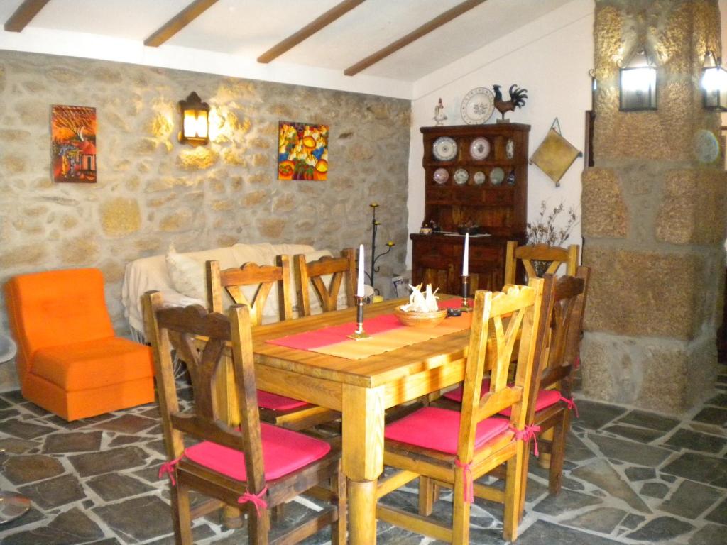 a dining room with a wooden table and chairs at Casa da Bemposta in Bemposta