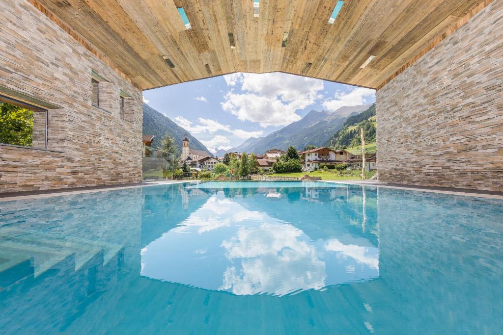 uma piscina com vista para as montanhas em Premium Activehotel Bergkönig em Neustift im Stubaital