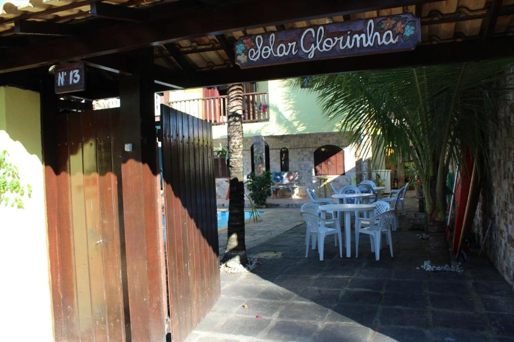 a restaurant with a table and chairs and a sign at Solar Glorinha in Búzios