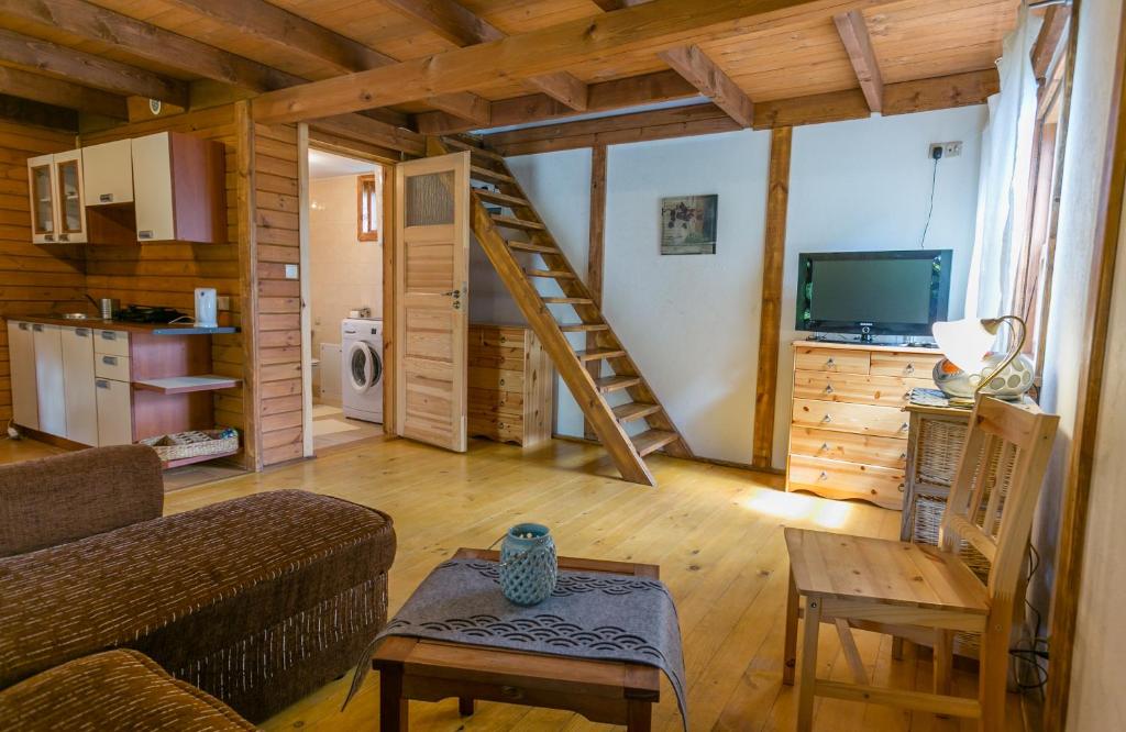 una sala de estar con sofá y una escalera en una casa en DOMKI POD JARZĘBINĄ en Puck