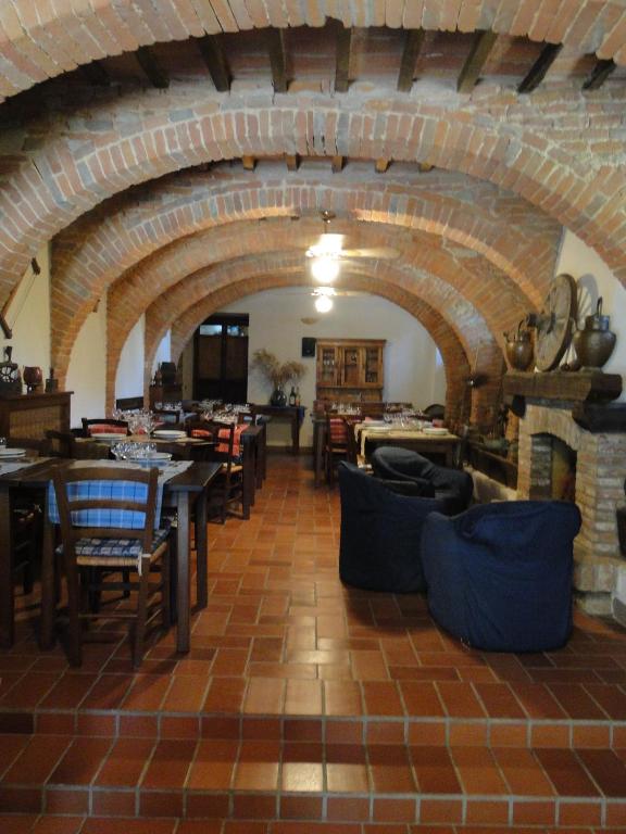 jadalnia ze stołami i krzesłami oraz ceglaną ścianą w obiekcie Agritur Villa Osvaldo Castiglione del Lago Perugia Colazione Piscina acqua salata w mieście Castiglione del Lago
