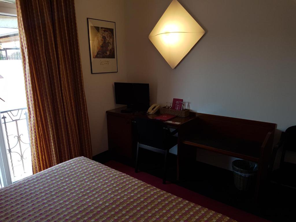 Postel nebo postele na pokoji v ubytování Cangrande Hotel