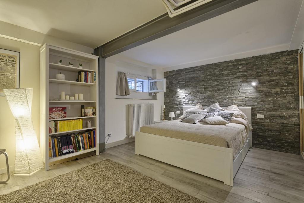 ボローニャにあるAppartamento Margheritaのレンガの壁、ベッド付きのベッドルーム1室