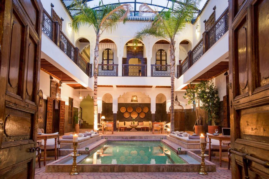 einen Innenpool in einem Gebäude mit Palmen in der Unterkunft Riad Kasbah & Spa in Marrakesch
