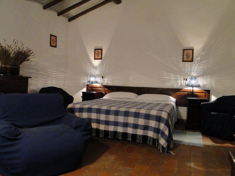 sypialnia z łóżkiem i 2 krzesłami w obiekcie Agritur Villa Osvaldo Castiglione del Lago Perugia Colazione Piscina acqua salata w mieście Castiglione del Lago