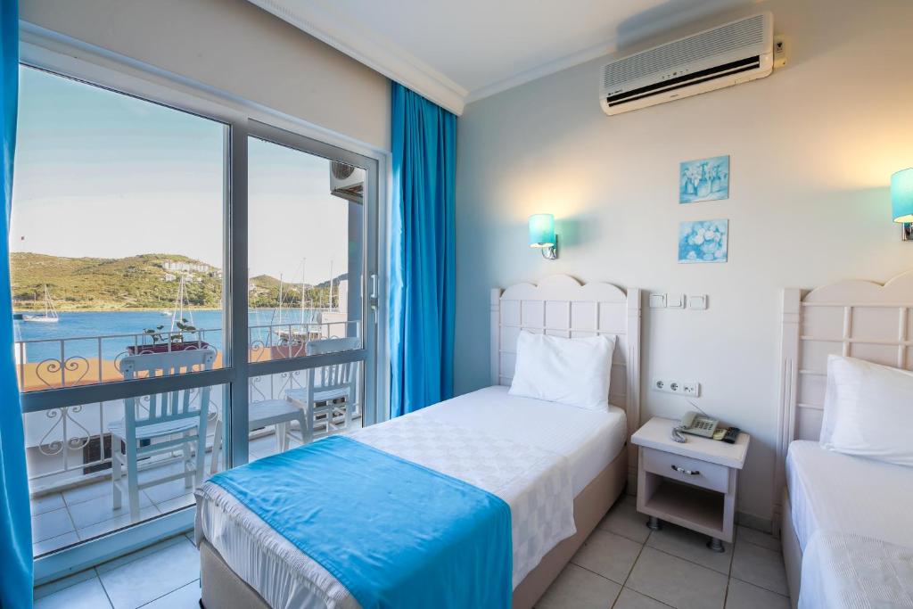 a hotel room with a bed and a balcony at Bora Hotel in Datca