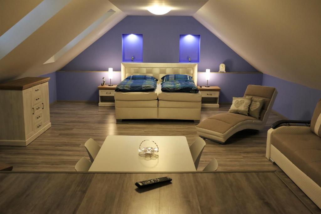 ein Wohnzimmer im Dachgeschoss mit einem Bett und einem Sofa in der Unterkunft Ubytovanie Tri ruže in Krásnohorské Podhradie