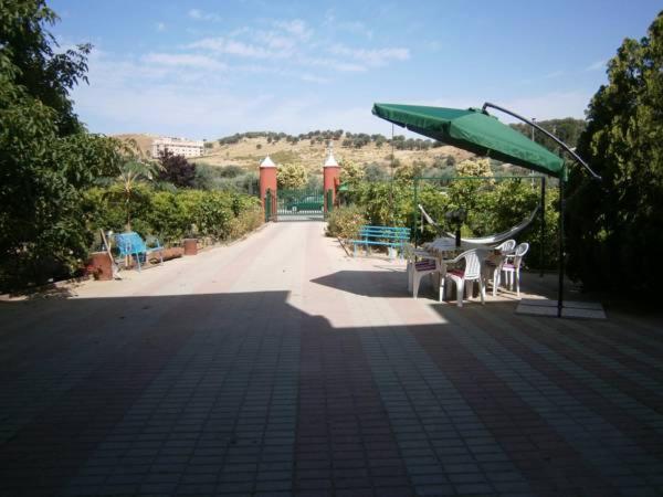 a patio with a green umbrella and tables and chairs at Bed and Breakfast L' Aranciera in Corigliano Calabro
