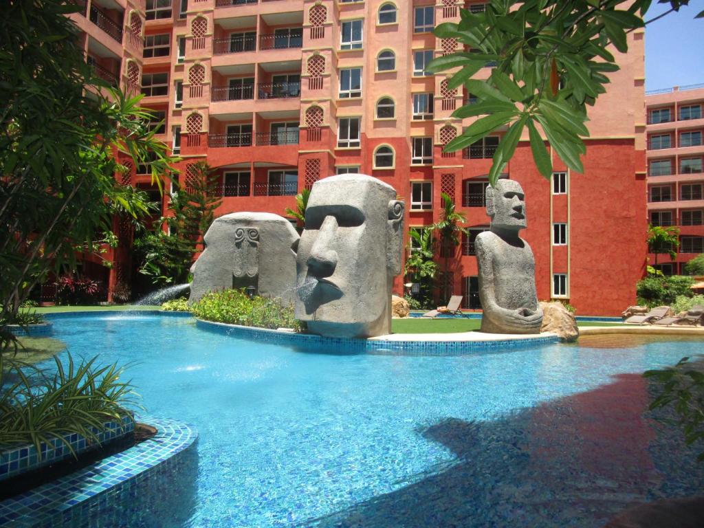 einem Pool mit Statuen vor einem Gebäude in der Unterkunft Seven Seas 410 in Jomtien Beach