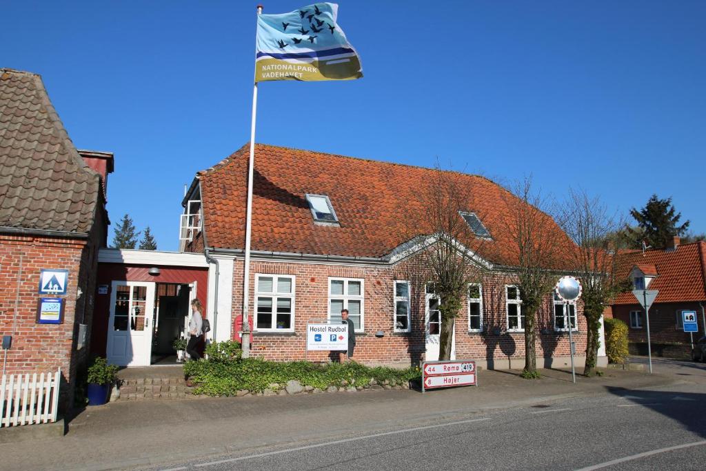 flaga pływająca przed ceglanym budynkiem w obiekcie Hostel Rudbøl w mieście Rudbøl