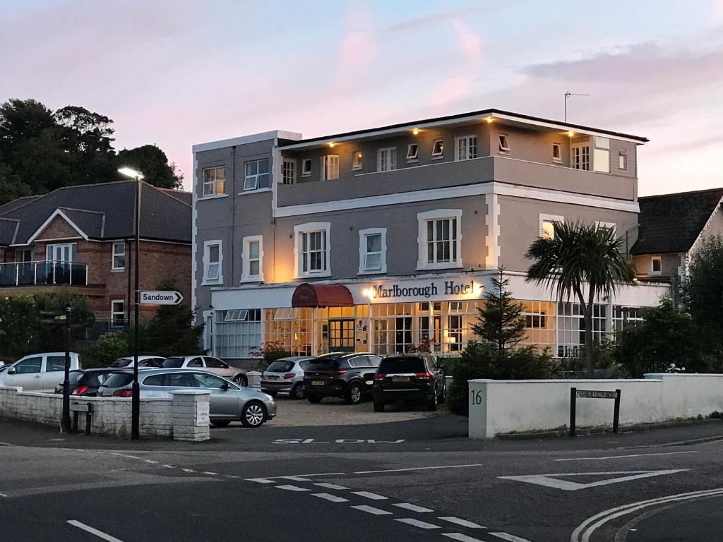 ein Gebäude mit Autos auf einem Parkplatz in der Unterkunft Marlborough Hotel in Shanklin